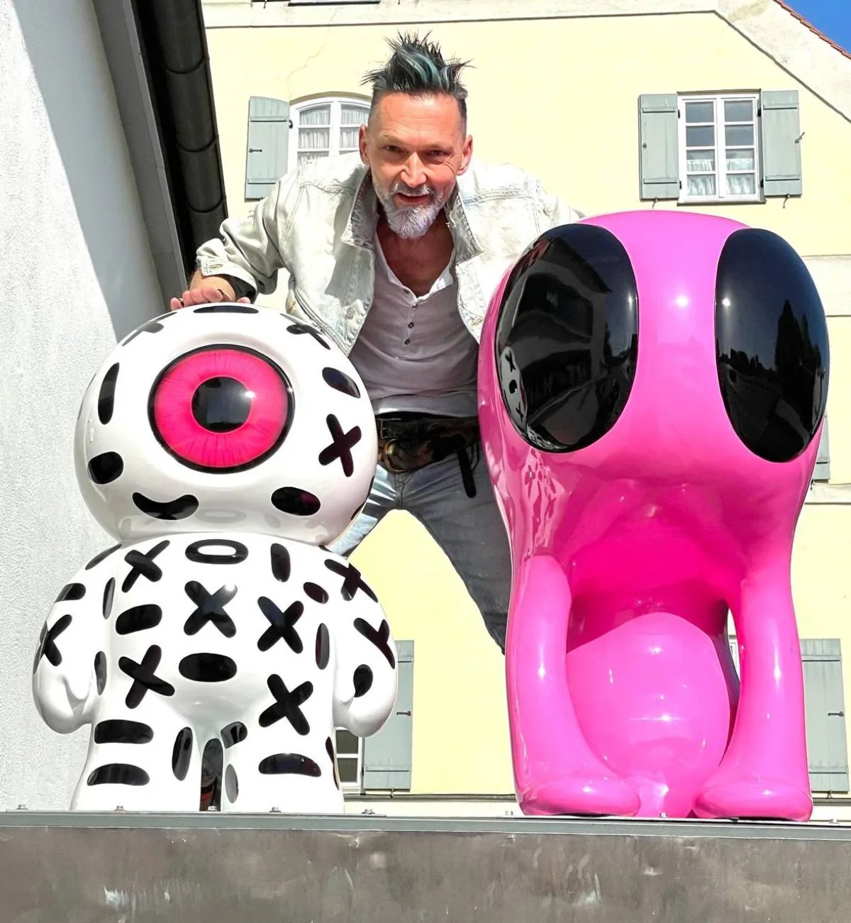 Günther Fischer mit zwei Figuren auf dem Vordach