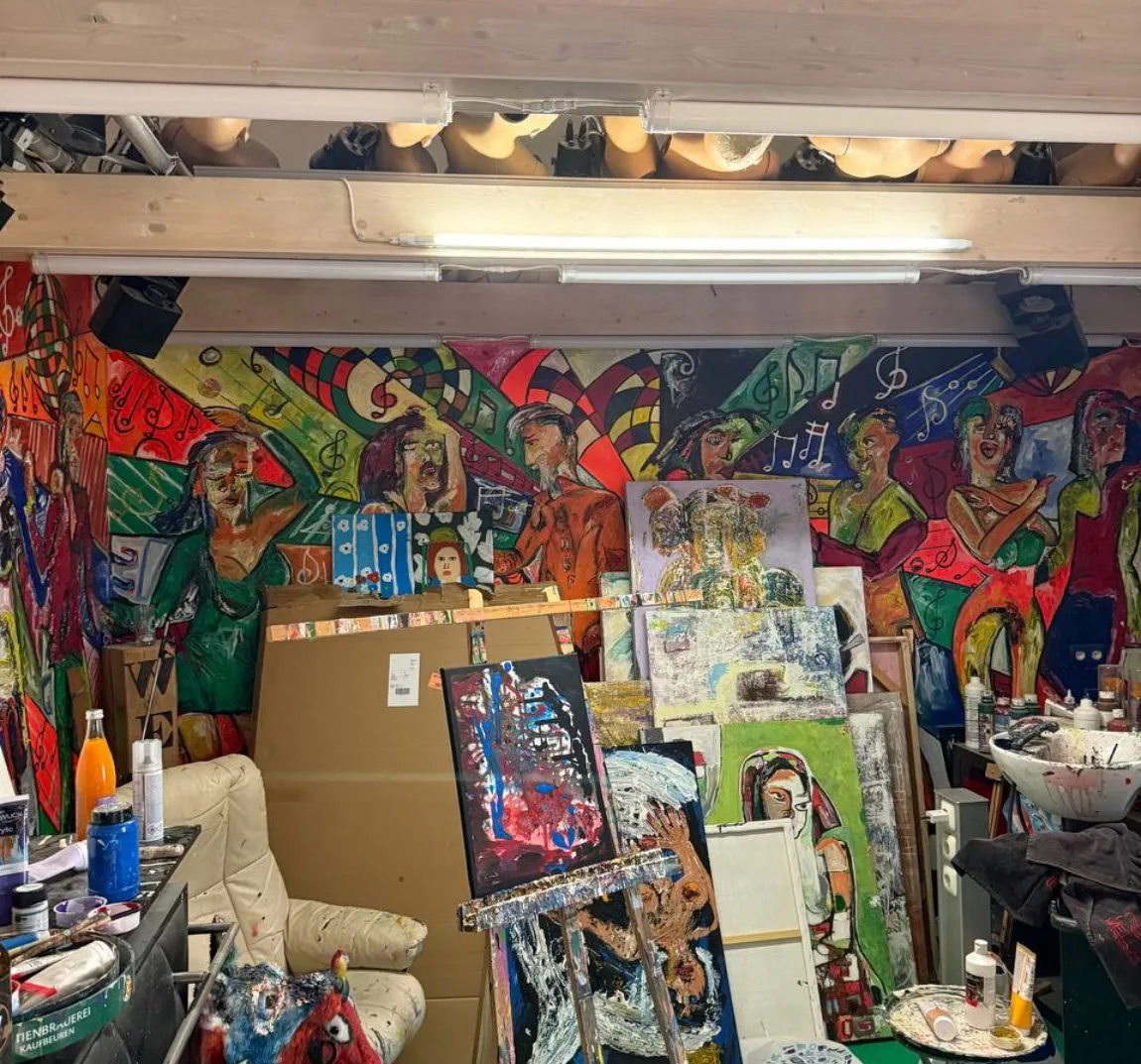 Epis Atelier unter dem Dach: Wandbild mit Musikern, Staffeleien, Leinwände, grüner Boden