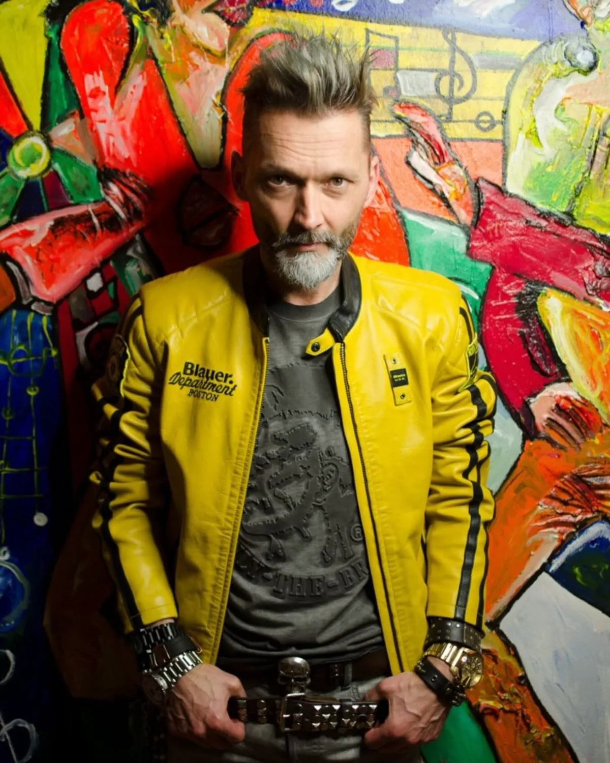 Günther Fischer in gelber Lederjacke vor einem bunten Wandbild
