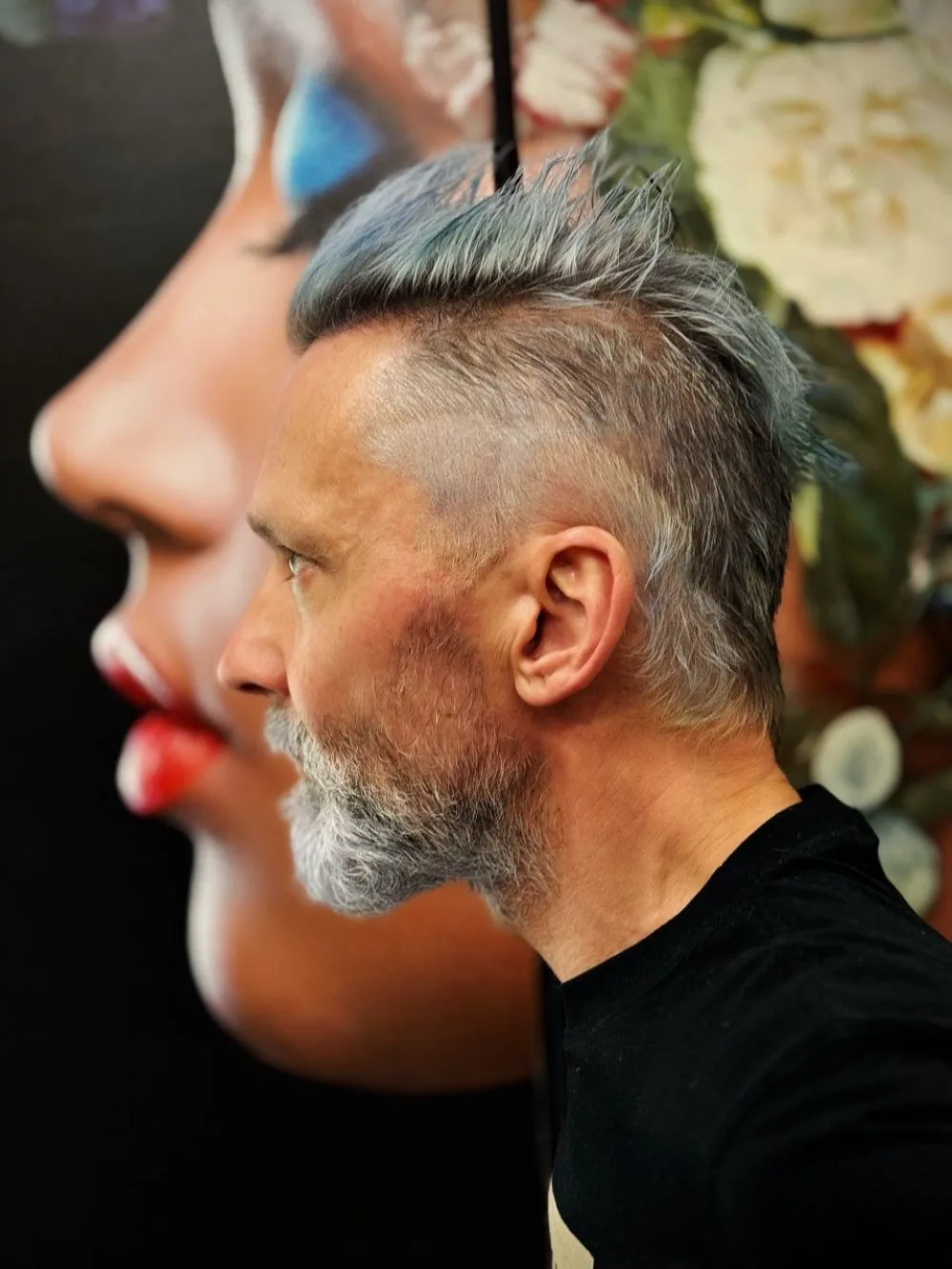Profil mit blau getönter Frisur vor einem Gemälde
